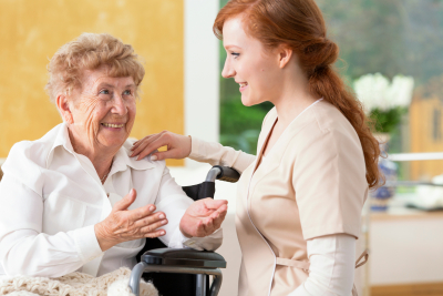 smiling senior woman talking to a friendly caregiver